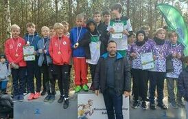 Obraz przedstawia tereny leśne na kt&oacute;rych znajduje się grupa os&oacute;b  stojących na podium